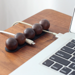 Adjustable Magnetic Walnut Cable Organizer in a warm desk setup