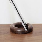 Round Walnut Phone Stand in a warm desk setup